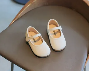 Nahaufnahme von weißen Mary-Jane-Schuhen für Mädchen mit weicher Sohle und Klettverschluss