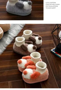 Detailed close-up of soft plush cartoon puppy slippers for babies in warm colors