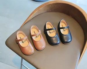 Detail klassischer schwarzer und brauner Leder-Slipper für Mädchen mit Klettverschluss