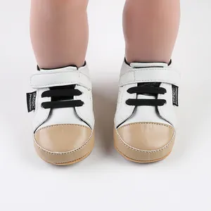 Front view detail of white and beige baby prewalker walking shoes with velcro straps