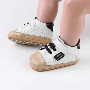 Detail view of white baby prewalker shoes with tan toe and magic tape closure