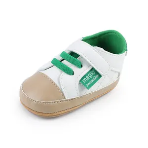 Detailed view of white and green infant pre-walker shoe with velcro strap design