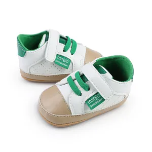 Close-up view of white and green baby pre-walker shoes with quilted stitch design