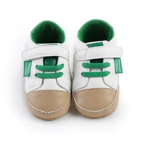 Front view detail of white and green baby pre-walker shoes with a secure Velcro strap