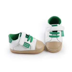 Close-up detail of white and green baby pre-walker shoes with velcro straps