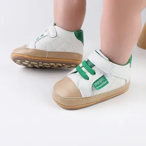 Close-up of white and green baby prewalker shoes with quilted side detail and Velcro strap
