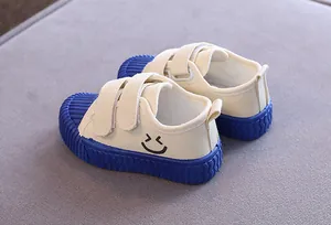 Detailansicht beige Kinder-Canvas-Schuhe mit blauer Gummisohle und Smiley-Grafikmuster