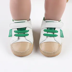 Close-up of white and green baby pre-walker shoes with magic strap on model feet