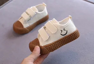 Detailansicht der weißen Kinder-Canvas-Schuhe mit süßem Smiley-Gesicht-Design