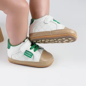 Detail of baby prewalker shoes with quilted pattern and green accents