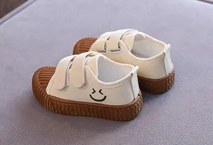 Cremefarbene Kinder-Leinenschuhe mit Smiley-Stickerei und robuster brauner Gummisohle