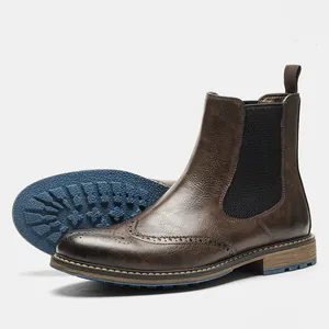 Professional detail of brown Brogue Chelsea boots showing wingtip carving and blue sole.