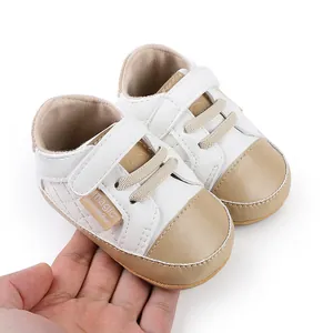 Detailed view of white and khaki baby pre-walker shoes with comfortable velcro strap