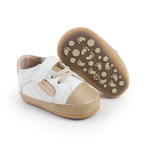 Detailed view of white and beige infant walking shoes featuring non-slip footprint soles