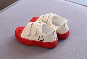 Detailansicht der Kinder-Canvas-Schuhe in Beige mit roter Keks-Sohle und einem Smiley
