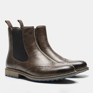 Detail view of men's brown brogue Chelsea boots with retro wingtip perforation pattern.