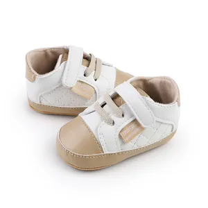 Close-up of white and beige baby walking shoes with quilted sides and velcro straps