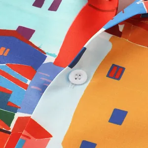 Close-up of colorful summer beach shirt featuring vibrant townscape print and white button.