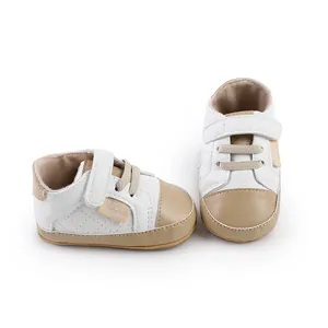 Close-up of white and beige soft sole baby walking shoes with velcro strap and quilted pattern