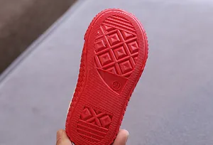 Detailansicht der roten rutschfesten Gummisohle für Kinder-Stoffschuhe