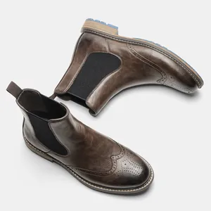 High-quality detail of brown men's Chelsea boots with retro brogue wingtip carving