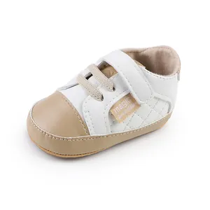 Side detail of a white and tan faux leather baby walking shoe with velcro strap.