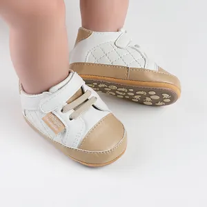 Detailed view of white and tan baby walking shoes featuring a velcro strap and soft sole
