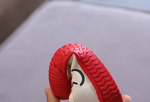 Detailansicht der hochflexiblen roten Gummisohle von Kinder-Leinenschuhen im Keks-Stil