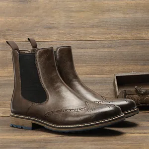 Close-up detail of classic brown vintage brogue wingtip Chelsea boots for men on wood
