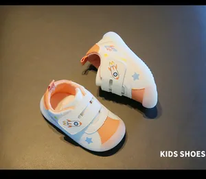 Detailed view of white and orange toddler walking shoes with cute rocket prints