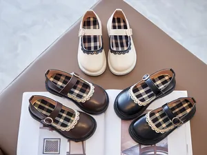 Close-up of girls' Mary Jane shoes in black, brown, and cream with lace trim.
