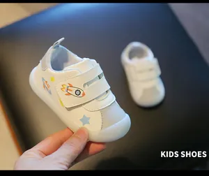 Detailed view of white kids walking shoes with rocket pattern and soft jelly sole
