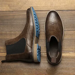 Macro detail of brown retro brogue Chelsea boots featuring unique blue textured rubber soles