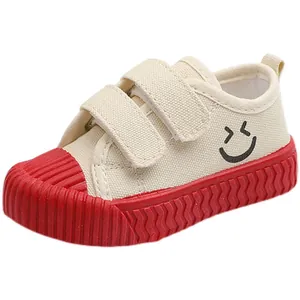 Bequeme weiße Kinder-Segeltuchschuhe mit roter Keks-Gummisohle und fröhlichem Smiley-Motiv