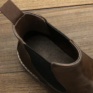 Detailed macro view of the interior insole and elastic side panel of a brown Chelsea boot