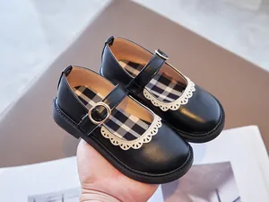 Detailed macro view of black Mary Jane shoes for girls featuring delicate white lace trim