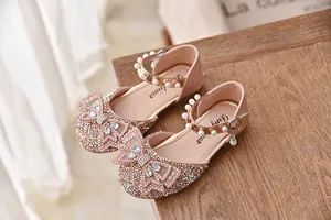 Detailopname van glitter prinsessenschoenen met strasstrik en parels