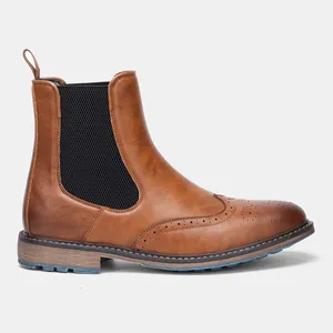 Side view detail of brown retro men's Chelsea boots with elegant brogue wingtip carving