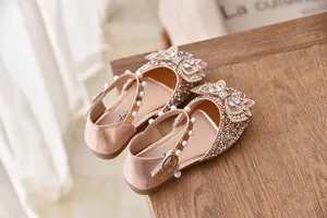 Detailopname van fonkelende roze prinsessenschoenen met strass strik en parels
