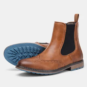Detailed view of brown brogue Chelsea boots featuring a textured blue rubber outsole