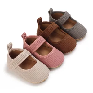 Détail de chaussures de marche pour bébé en velours côtelé rose, beige, marron et gris