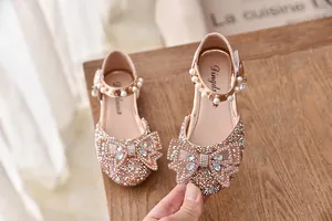 Detail van glitterende roze prinsessenschoenen voor meisjes met strasstrik en parels