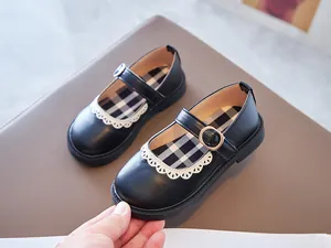 Close-up of black Mary Jane shoes for girls featuring white lace trim and plaid insole
