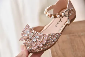 Detailopname van de sprankelende strass-strik en parels op roze prinsessenschoenen