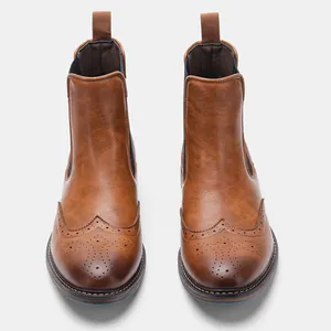 Front view of brown leather Chelsea boots with classic brogue wingtip detailing.
