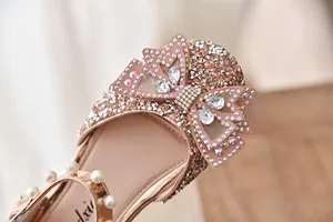 Detailopname van glinsterende strass-strik op elegante roségouden prinsessenschoenen