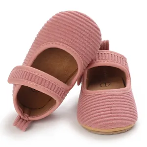 Détail de chaussures de marche pour bébé fille en velours côtelé rose, semelle souple
