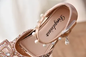 Detail van roze prinsessenschoenen voor meisjes met parelbandje en glimmende strass