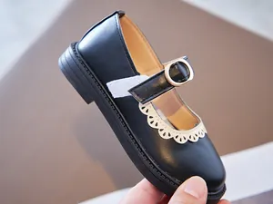 Close-up view of black girls' Mary Jane shoes with elegant white lace scalloped trim