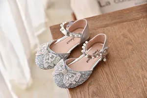 Detailweergave van zilveren glitter prinsessenschoenen met strass strik en parels.